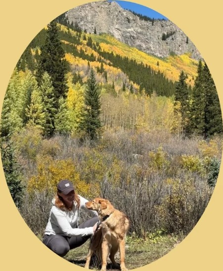 Trainer with a dog among fall aspens
